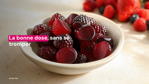 Des gummies rouges en forme de fruits dans une coupelle blanche sur une table crème.
