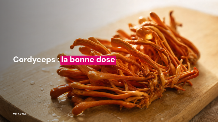 Gros plan de champignons cordyceps orange sur une planche en bois.