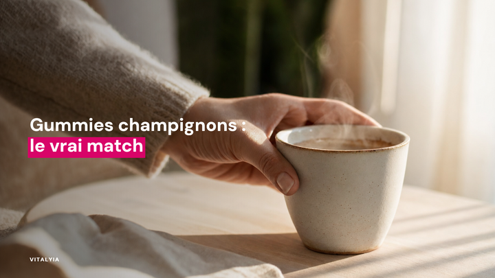 Une main tient une tasse fumante sur une table en bois